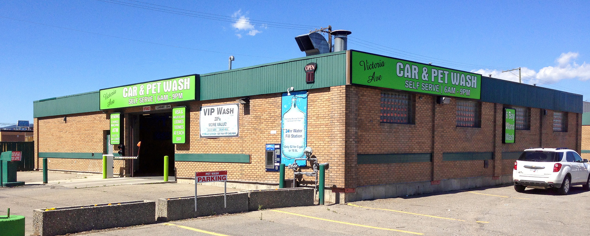 Exterior of Victoria Ave Car & Pet Wash in Cranbrook, with green signage and a large parking lot 