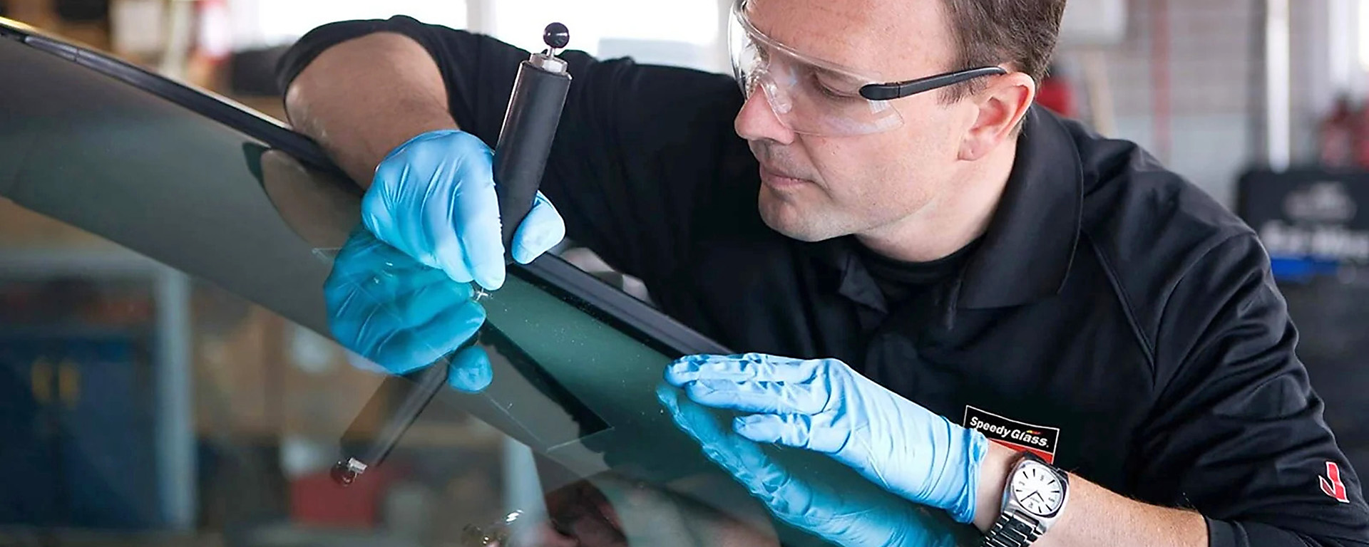 Speedy glass employee fixing crack in windshield. 