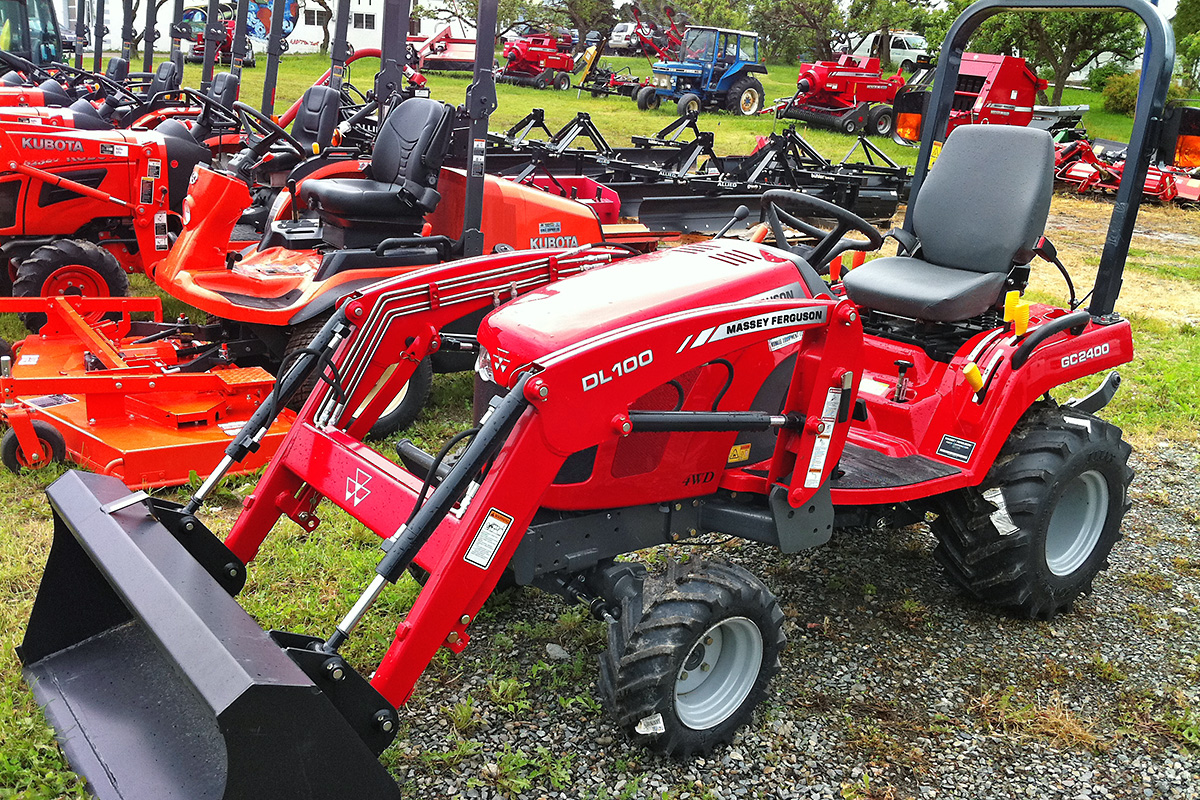 Red tractors and mowers parked outside 