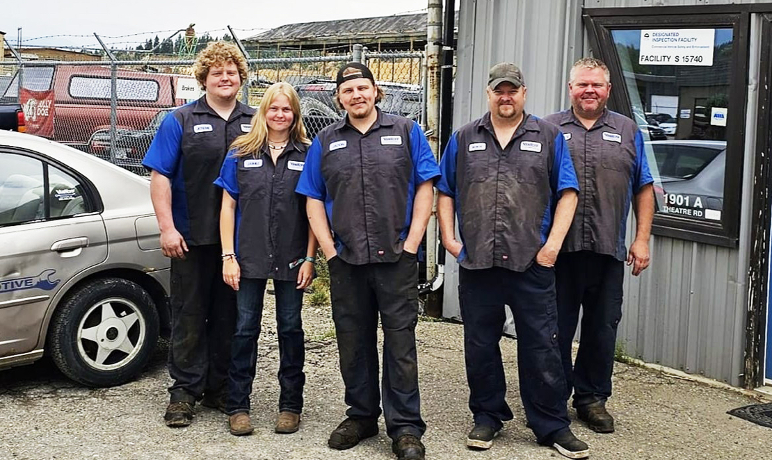 The VanHoff staff team standing outside the company building, wearing blue and black uniforms 