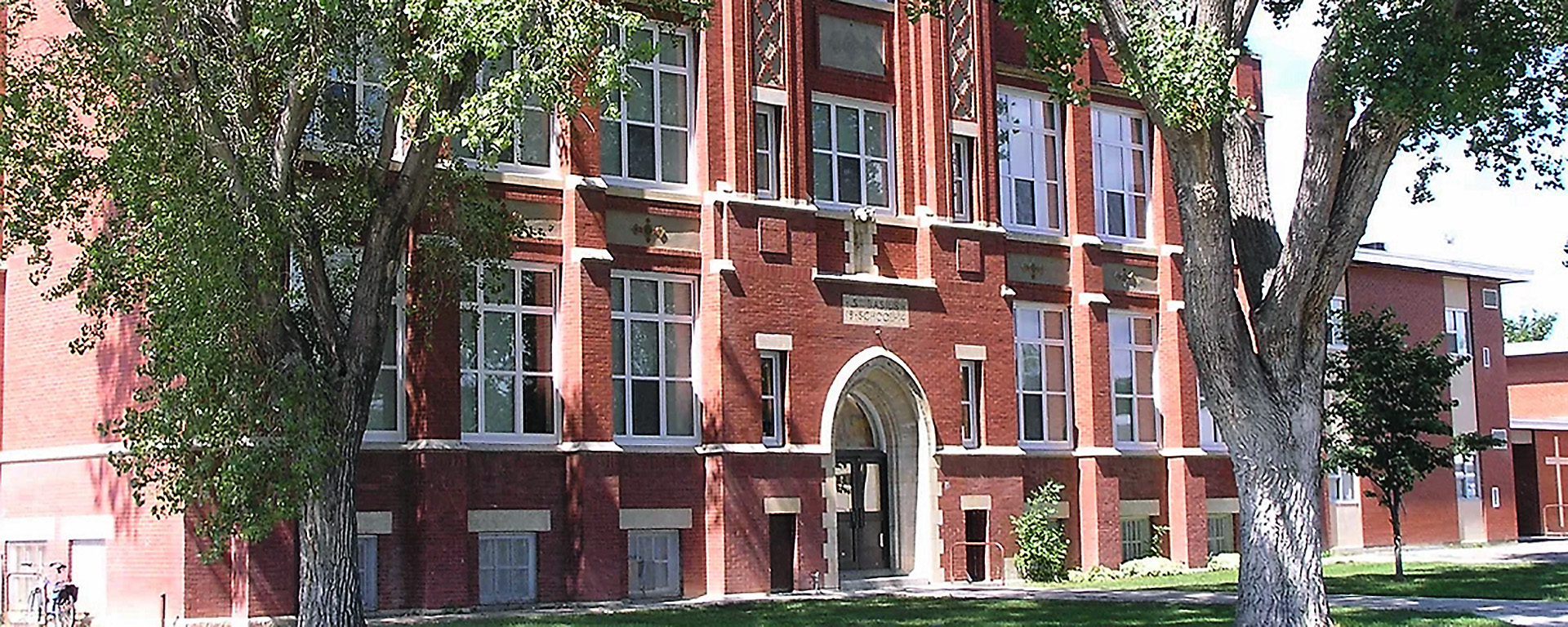 A large brick building with many multi-panelled PVC windows installed on each floor. 