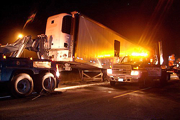 semi truck being towed away at the scene of an accident