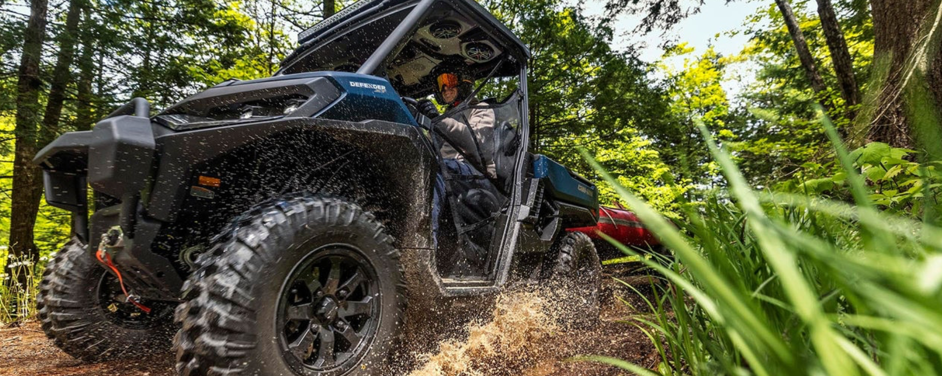 An ATV being driven through the mud, shot from below to show the grass and splash 