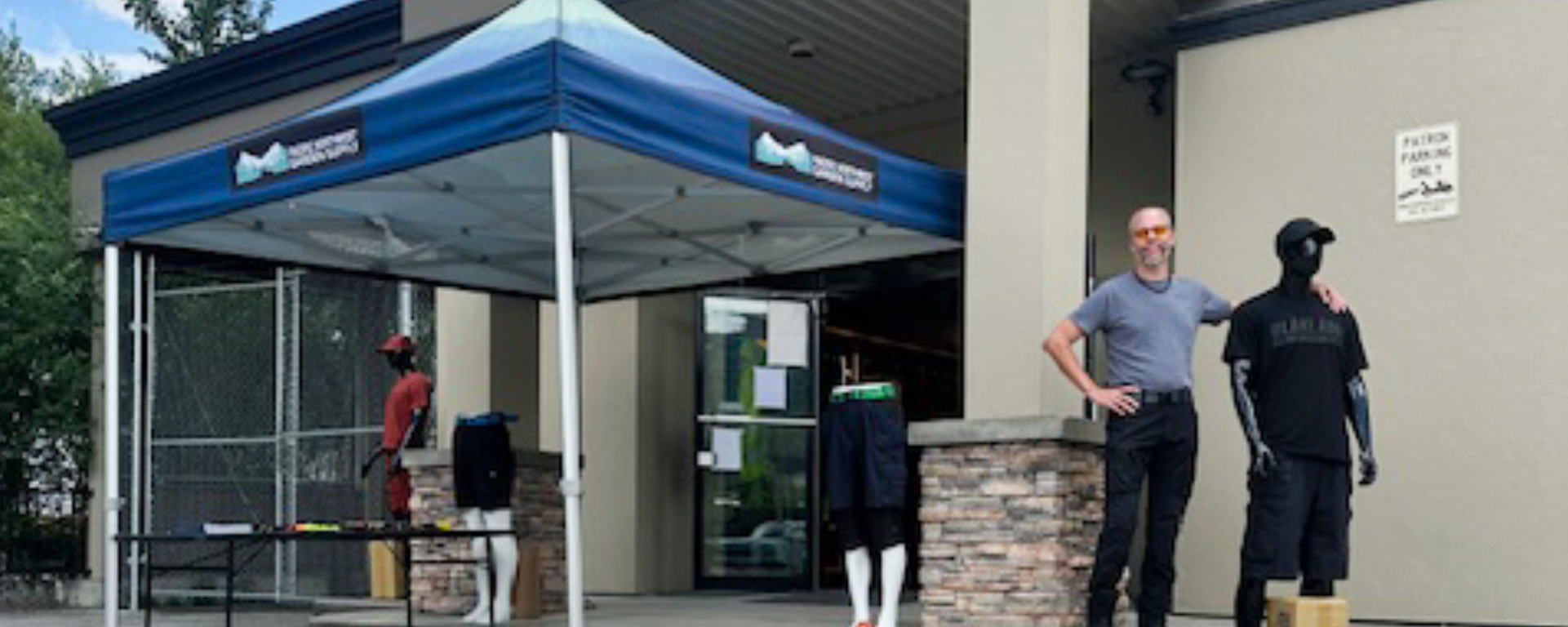 David Robinson standing in front of the PNW Mercantile & Supply Co. store, next to several mannequins wearing store apparel. 