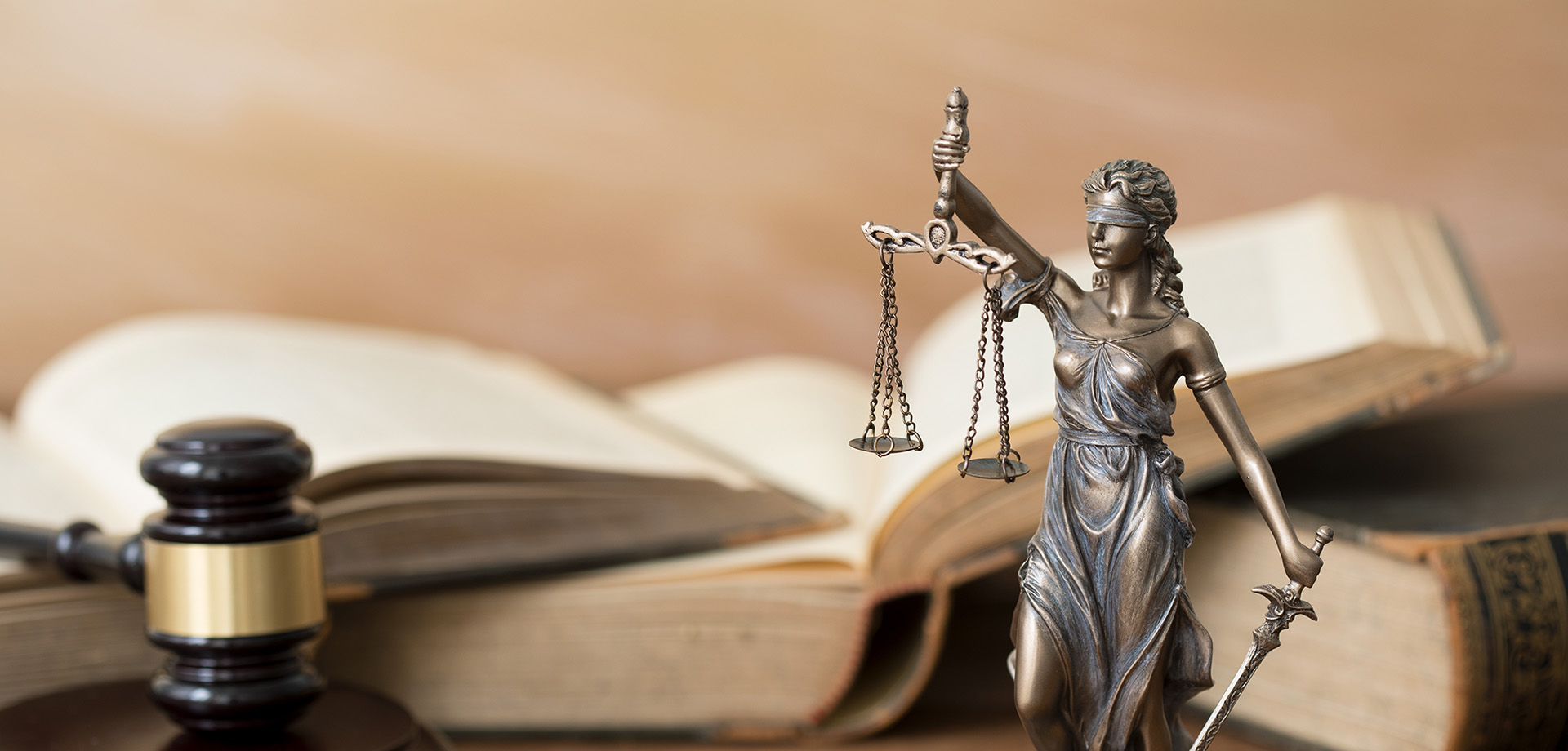 Themis statue, books and gavel on wooden table 