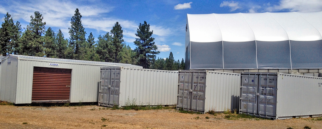 A storage building and three portable storage sea cans for rent in Cranbrook 