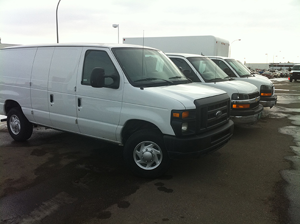 Line up of white vehicles outside for rent