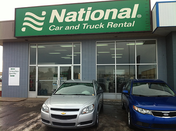 Car parked outside building advertising National Car and Truck Rental