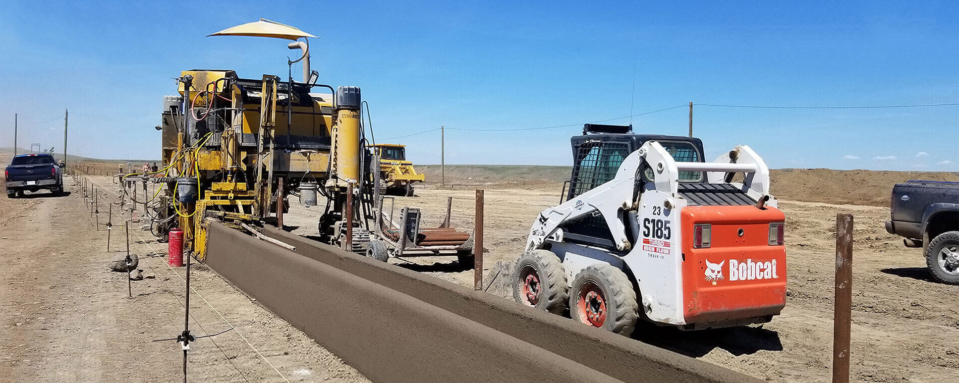Specialized machinery on a job site, making a concrete slip-formed feed bunk. 