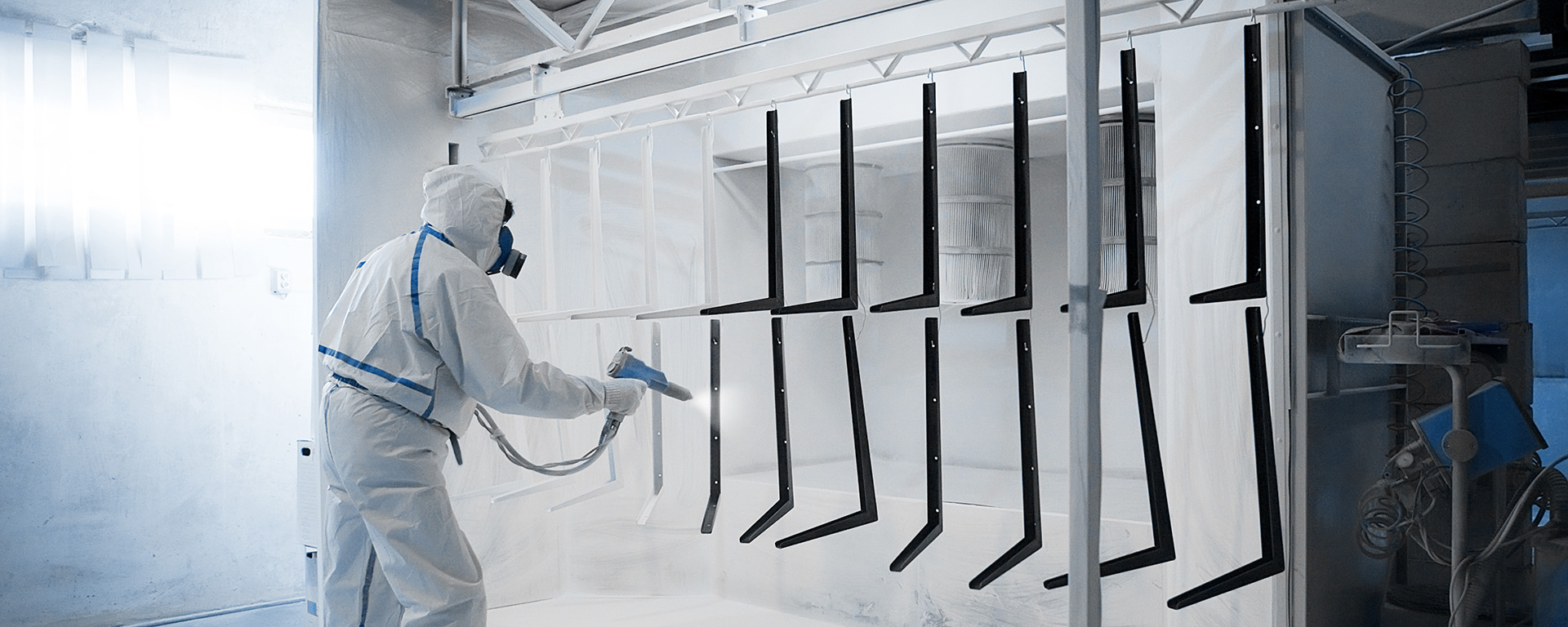 Worker wearing protective wear performing powder coating