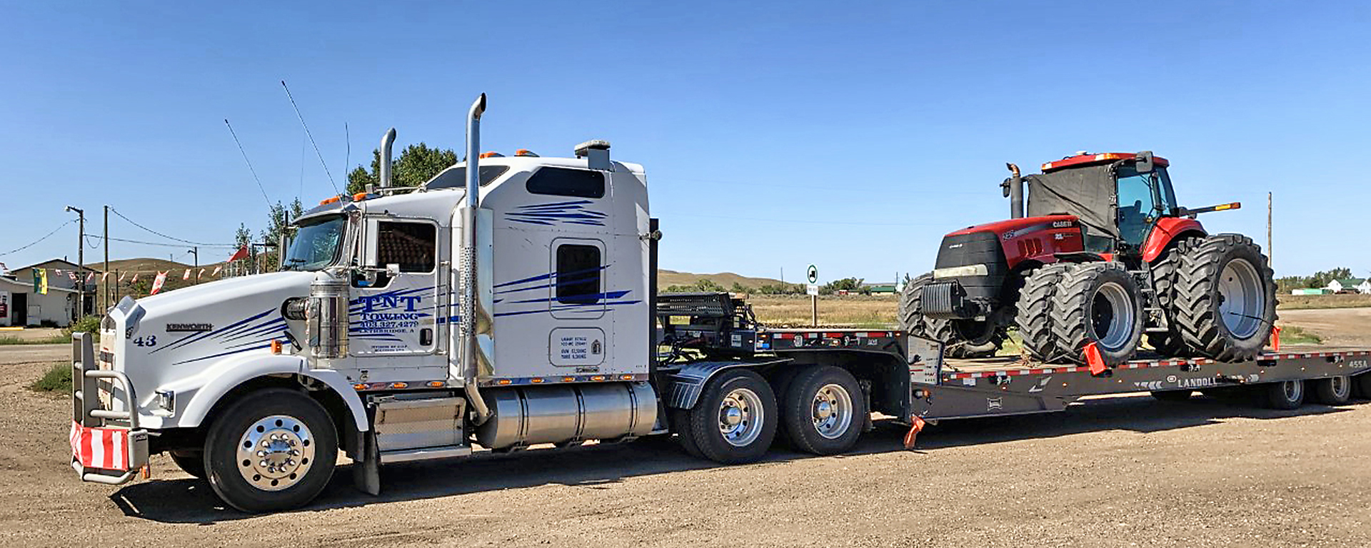 TNT tow truck hauling a tractor 