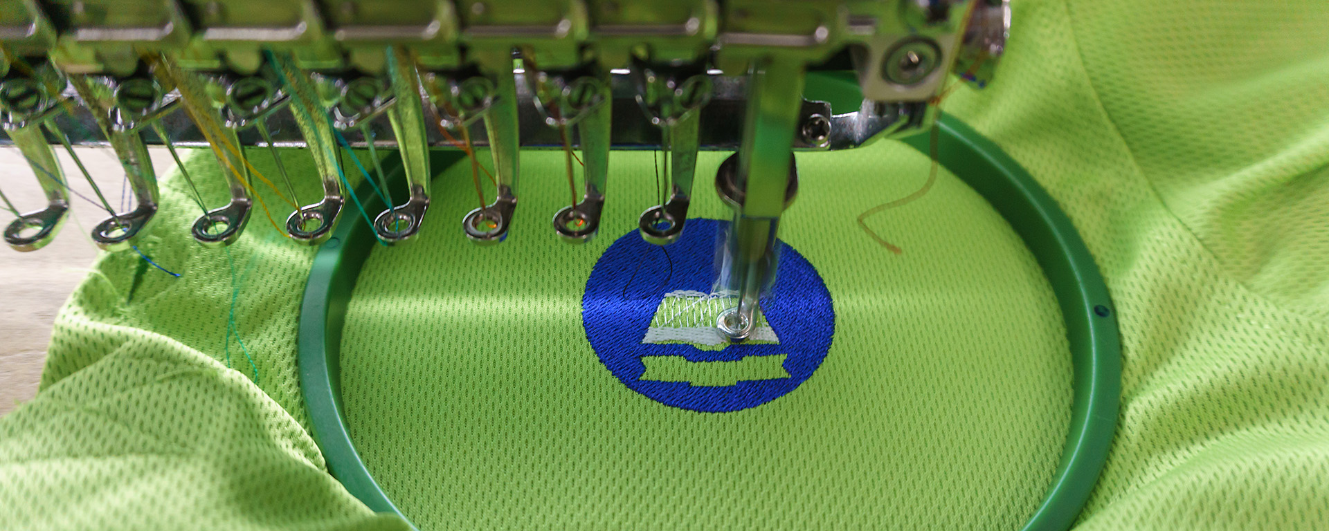 an embroidery machine embroidering a logo on a shirt 