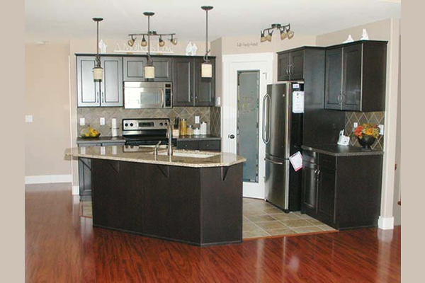 Kitchen containing dark wood cupboards and white pantry door