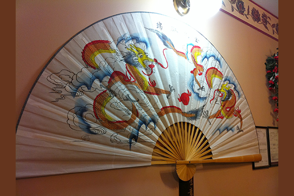 An oriental fan displayed on the wall
