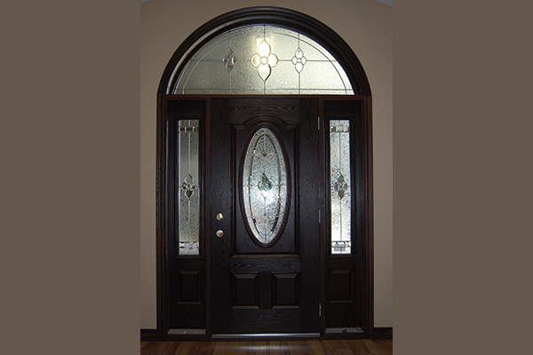 Dark coloured door with a semi-circle window above
