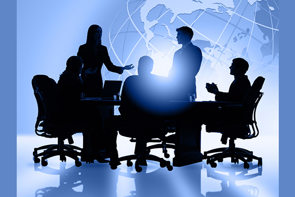 Silhouette of five people having a meeting at a big table