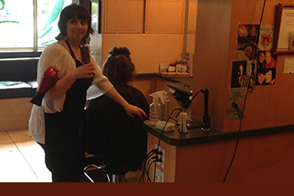 Inside the salon where a stylist is performing hair services on a client