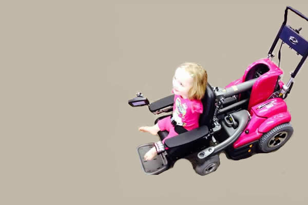 a little girl sitting in a black and pink custom wheelchair