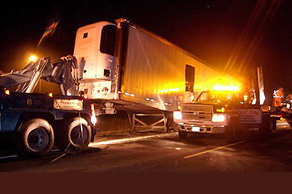 semi truck being towed away at the scene of an accident