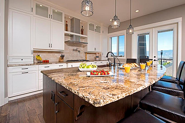 Open kitchen concept with granite countertop island and white cupboards