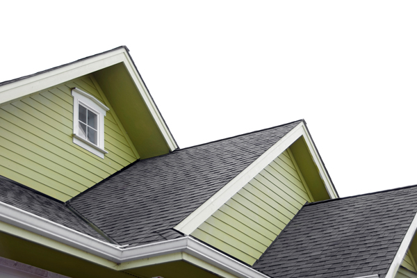 green siding on a home with dark brown shingles on a roof