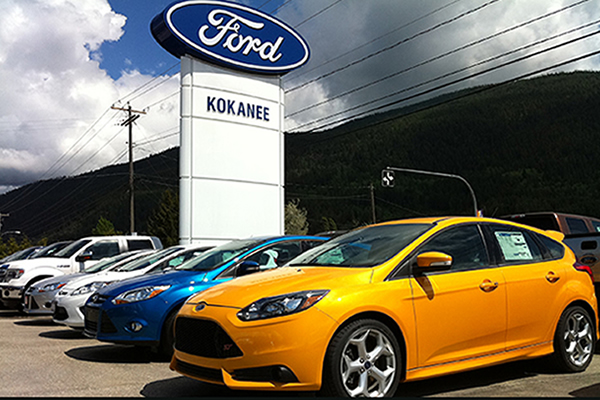 Various Ford cars parked by outside Ford sign