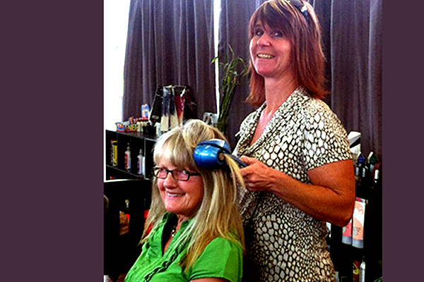 Seana Coolbaugh ironing Dodi Dube's hair