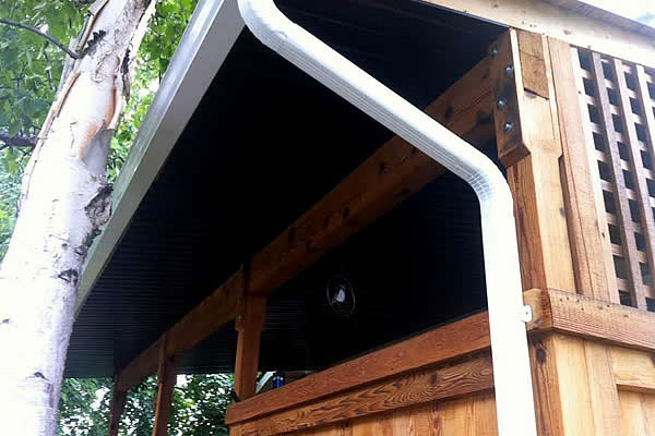 white eavestroughing and gutters on a wooden home