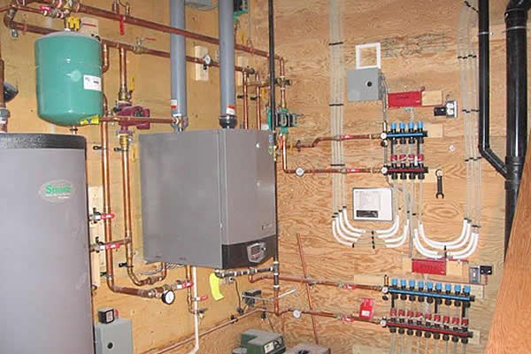 tanks, pipes, and a hot water tank mounted on a wall