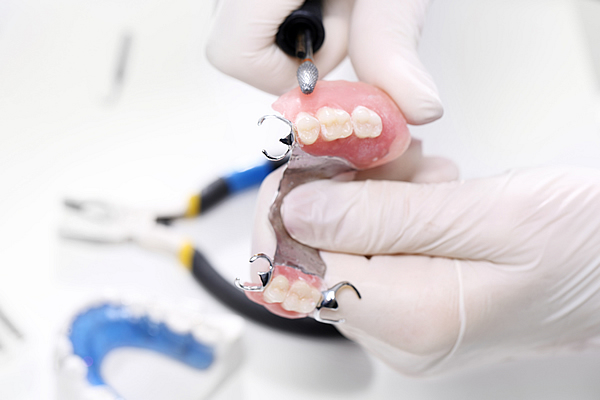partial dentures being worked on with tools in a laboratory