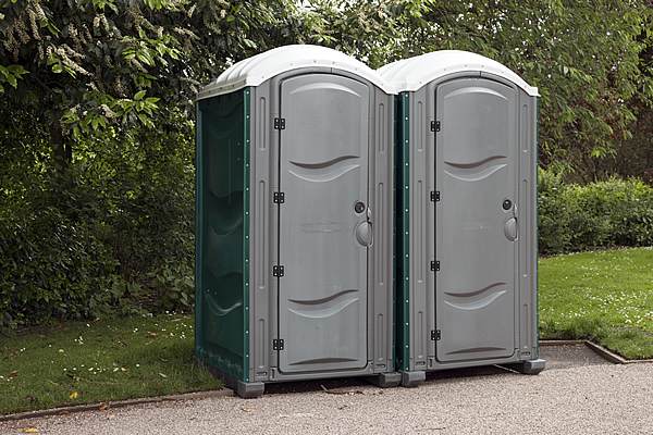two stand up portable toilets that are used for rental purposes at outdoor events