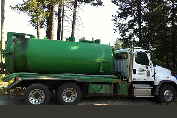 utility truck with a white cab and green tank