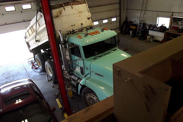 turquoise coloured dump truck parked in the shop