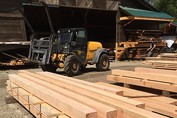 forklift onsite at a mill moving piles of lumber to different ends of the yard