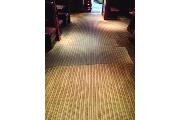 Half cleaned carpet at a high traffic area in restaurant 