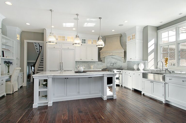 Modern kitchen with pendant lighting, white cabinets and stainless steel appliances and fixtures 