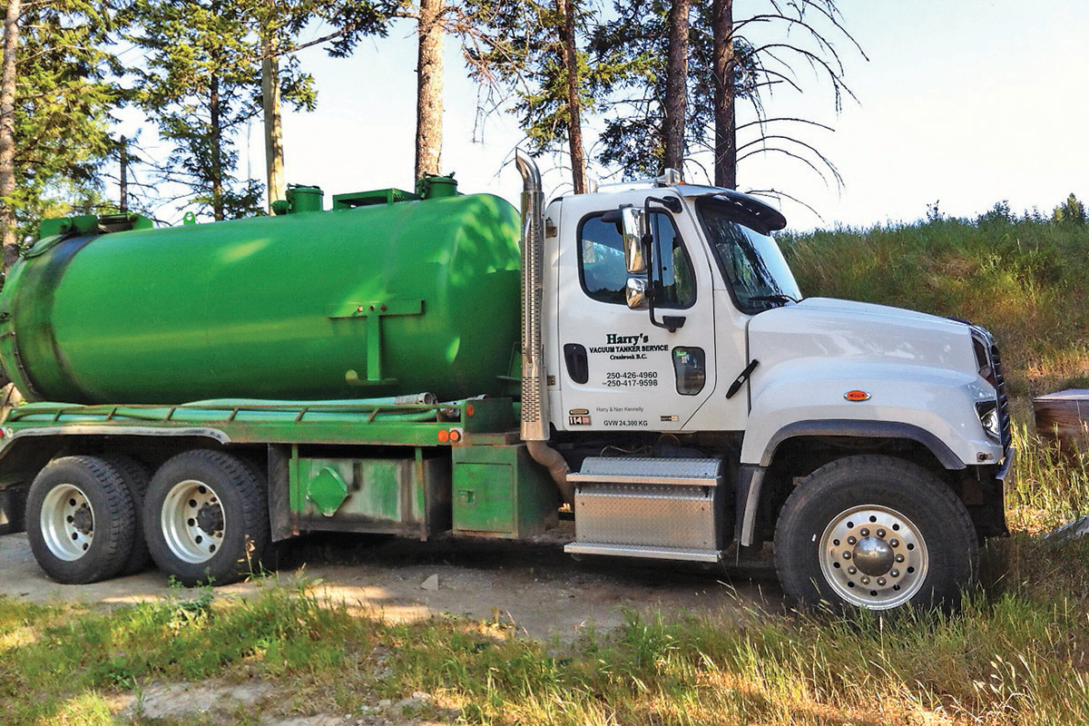 utility truck with a white cab and green tank 