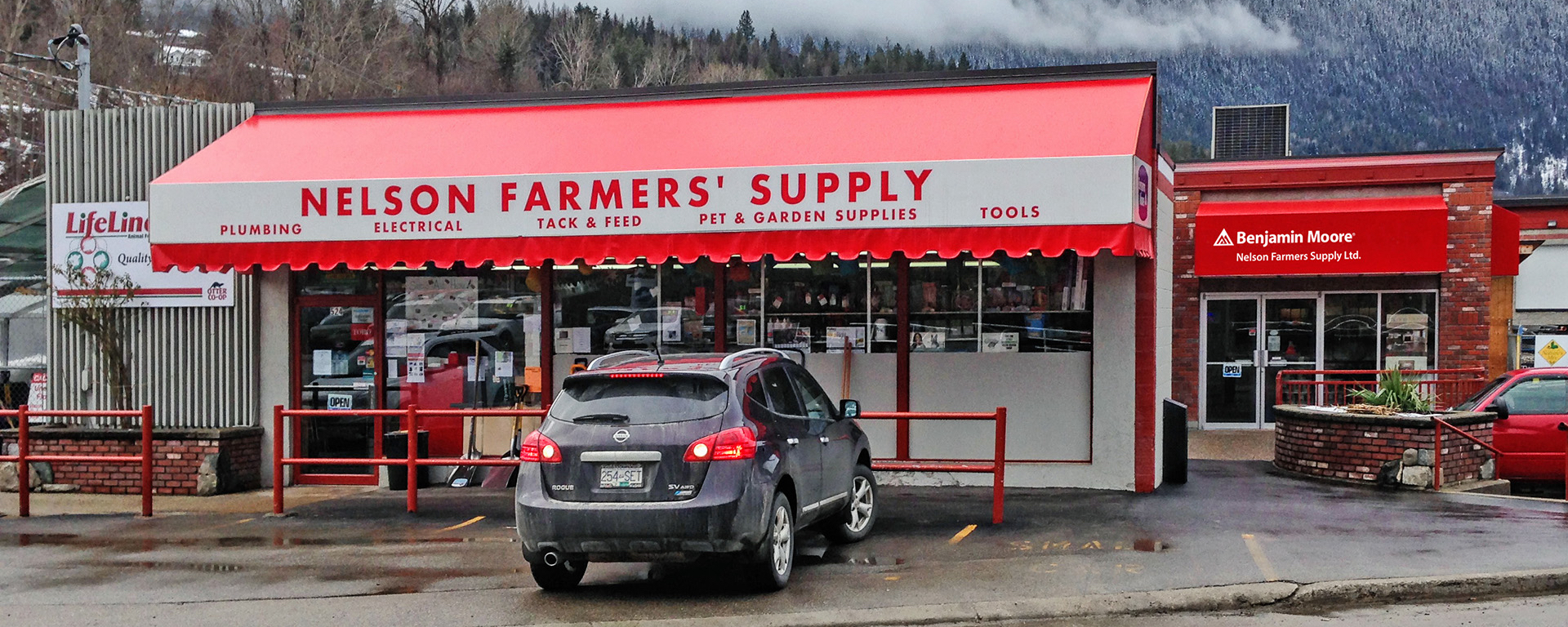 Exterior of Nelson Farmers Supply building with red lettering on white signage 