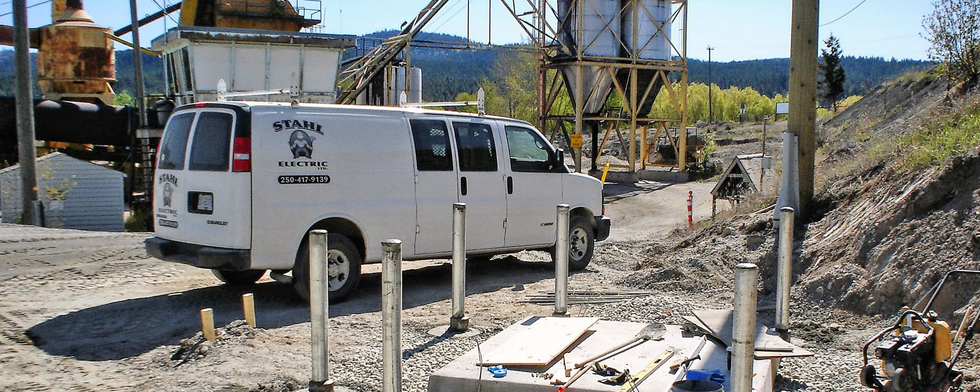A white van with the Stahl Electric logo is parked at an industrial jobsite. 