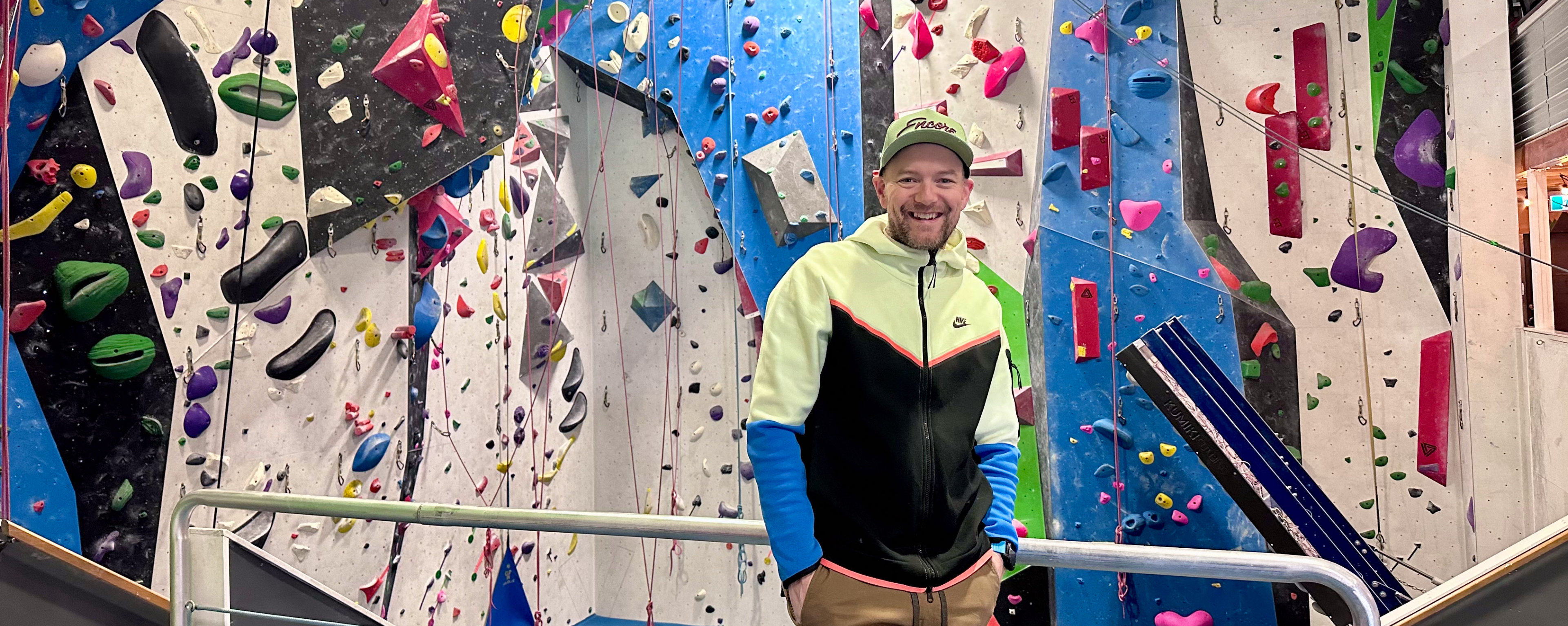 Gordon, the owner of Arq Climbing Centre in Cranbrook in front of a climbing wall 